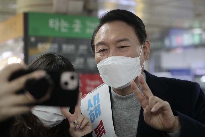 [서울=뉴시스] 전신 기자 = 윤석열 국민의힘 대선 후보가 설 연휴 첫날인 지난 29일 서울 강남역을 찾아 시민들과 인사하며 기념촬영하고 있다.  (사진=국민의힘 선대본 제공) 2022.01.29. photo@newsis.com *재판매 및 DB 금지