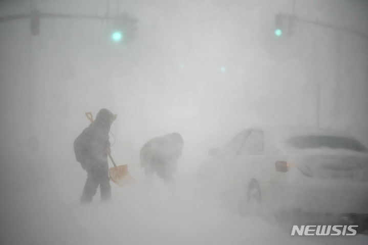 [프로비던스(미 로드아일랜드주)=AP/뉴시스]미 로드아일랜드주 프로비던스에서 29일(현지시간) 폭설로 발이 묶인 운전자 한 명이 삽을 든 행인의 도움을 받고 있다. 허리케인급의 돌풍을 동반한 폭풍이 29일 미 동북부 지역을 강타해 45㎝가 넘는 폭설이 쏟아지고, 해안가에 홍수가 발생했으며 광범위한 정전이 발생할 수 있다고 예보됐다. 기상 예보관들은 상황이 더 악화되고 매서운 추위가 뒤따를 것이라고 경고했다. 2022.1.30