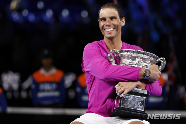 [멜버른=AP/뉴시스] 라파엘 나달이 30일 호주 멜버른 로드 레이버 아레나에서 열린 2022 호주오픈 테니스 남자단식에서 우승을 차지한 뒤 우승 트로피인 노만 브룩스 챌린지 컵을 품에 안고 환하게 웃고 있다. 2022.01.31.