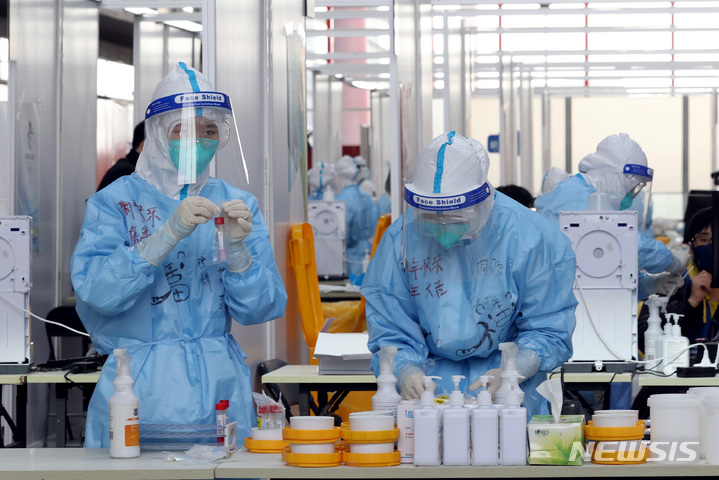 [베이징(중국)=뉴시스] 김병문 기자 = 31일 오후 중국 베이징 서우두 국제공항에서 방호복을 입은 보건요원들이 입국자들을 대상으로 코로나19 검사를 진행하고 있다. 2022.01.31. dadazon@newsis.com