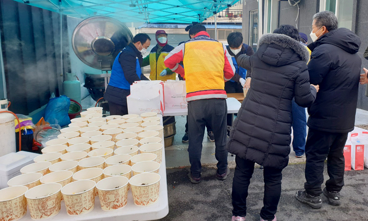 [광주=뉴시스] 설 명절 당일인 1일 오전 화정1동 한 상가에서 광주시 자원봉사자센터 소속 자원봉사자 20여명과 서구청 직원들 3명이 떡국 400그릇 나눔 행사를 열고있다. (사진=광주 서구 제공) 2022.02.01 photo@newsis.com *재판매 및 DB 금지