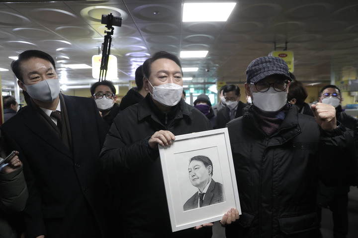 [서울=뉴시스] 최동준 기자 = 윤석열 국민의힘 대선 후보가 1일 인천 강화풍물시장을 방문해 시민들과 그림을 선물받고 기념촬영을 하고 있다. (사진=국민의힘 선대위 제공) 2022.02.01. photo@newsis.com *재판매 및 DB 금지