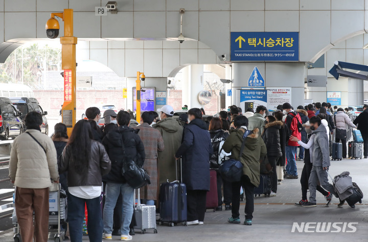 [제주=뉴시스] 우장호 기자 = 설 연휴 마지막 날인 2일 오후 제주국제공항 1층 택시승차장에 관광객들의 줄이 길게 늘어서 있다. 중앙방역본부에 따르면 전날 제주 도내 일일 코로나19 확진자 수는 122명으로 역대 최다를 기록했다. 2022.02.02. woo1223@newsis.com