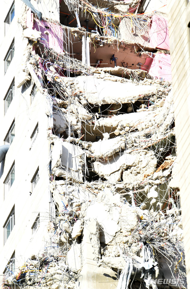 [광주=뉴시스] 변재훈 기자 = 3일 오후 광주 서구 HDC현대산업개발 신축 아파트 붕괴 사고가 난 201동 남서쪽 29층에서 무너져 내린 콘크리트·철근 잔해 더미가 외벽에 걸쳐져 있다. 지난 2일 추가 붕괴 이후 안전 문제로 작업이 일시 중단됐으나 이날 오후 4시 30분부터 구조대원이 건물로 재진입, 수색·구조 작업을 벌인다. 2022.02.03. wisdom21@newsis.com