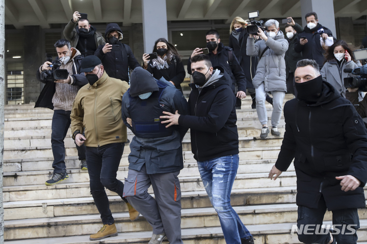 [테살로니키(그리스)=AP/뉴시스]그리스 사복 경찰들이 지난 3일 북부 테살로니키의 법원에서 지난달 31일 경쟁 관계인 축구 클럽 팬 알키스 캄바노스(19)를 살해한 혐의를 받고 있는 23살의 남성 한 명을 끌고 나오고 있다. 경찰은 6일 체포영장이 발부된 8명을 추가로 체포했다고 밝혔다. 1명은 이웃 알바니아로 도피한 것으로 알려졌다. 2022.2.7 