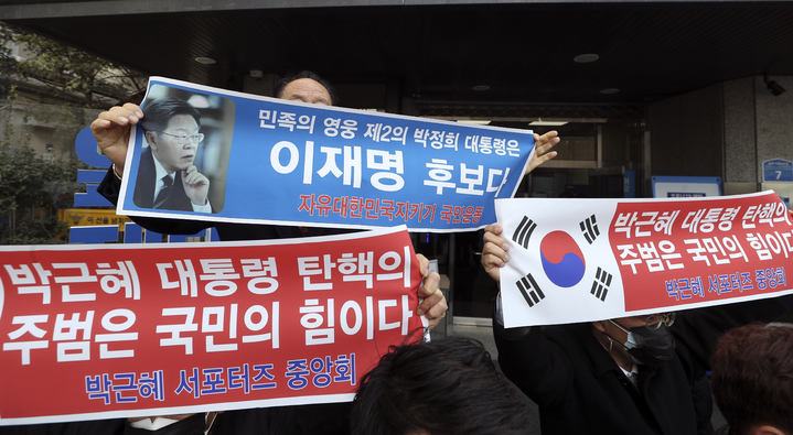 [서울=뉴시스] 최진석 기자 = 박근혜 서포터즈 중앙회 등 보수진영 애국 단체 일부 회원들이 4일 서울 여의도 더불어민주당 중앙당사 앞에서 이재명 더불어민주당 대선 후보 지지 펼침막을 들고 있다. 2022.02.04. myjs@newsis.com