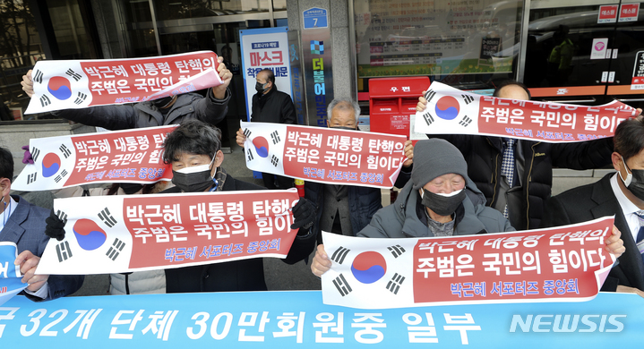 [서울=뉴시스] 최진석 기자 = 박근혜 서포터즈 중앙회 등 보수진영 애국 단체 일부 회원들이 4일 서울 여의도 더불어민주당 중앙당사 앞에서 이재명 더불어민주당 대선 후보 지지하며 펼침막을 들고 있다. 2022.02.04. myjs@newsis.com