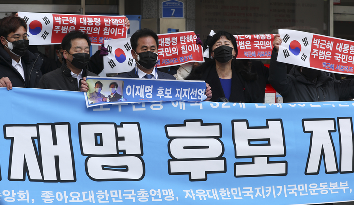 [서울=뉴시스] 최진석 기자 = 박근혜 서포터즈 중앙회 등 보수진영 애국 단체 일부 회원들이 4일 서울 여의도 더불어민주당 중앙당사 앞에서 이재명 더불어민주당 대선 후보 지지 펼침막을 들고 있다. 2022.02.04. myjs@newsis.com