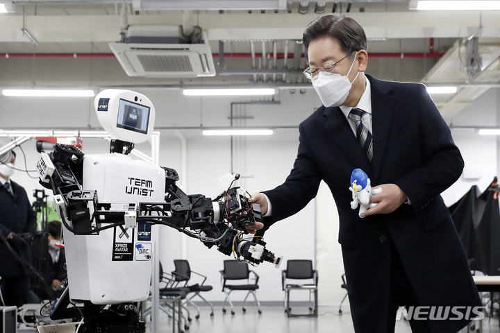 [울산=뉴시스] 최동준 기자 = 이재명 더불어민주당 대선 후보가 5일 울산 울주군 울산과학기술원을 방문해 원격 조정 로봇과 악수를 하고 있다. 2022.02.05. photocdj@newsis.com