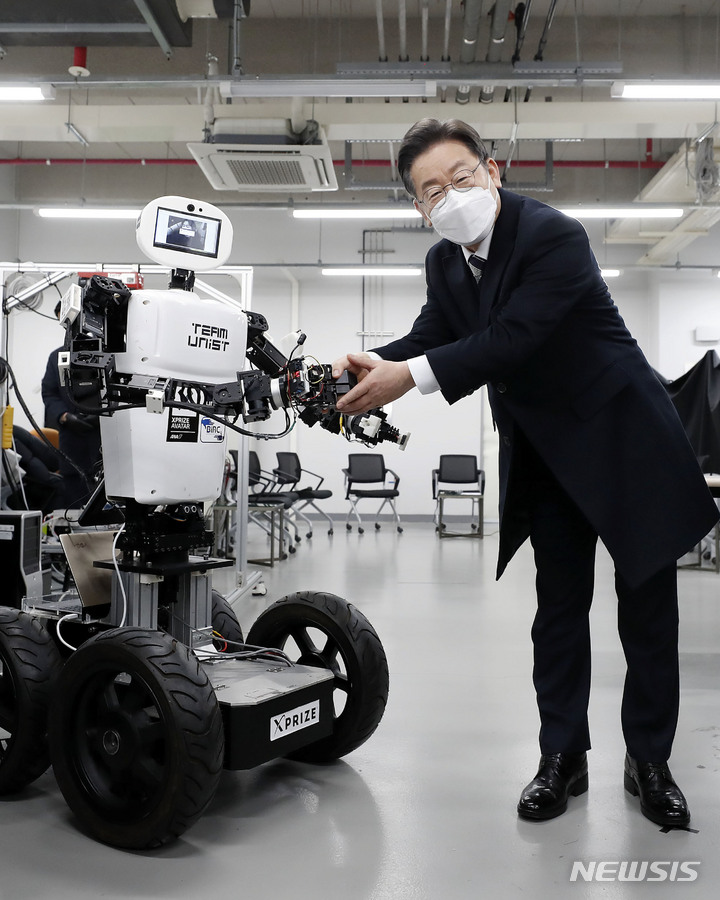 [울산=뉴시스] 최동준 기자 = 이재명 더불어민주당 대선 후보가 5일 울산 울주군 울산과학기술원을 방문해 원격 조정 로봇과 악수를 하고 있다. 2022.02.05. photocdj@newsis.com