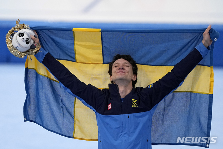 [베이징=AP/뉴시스] 닐스 판데르폴(스웨덴)이 6일 중국 베이징 국립스피드스케이팅오벌에서 열린 2022 베이징동계올림픽 스피드스케이팅 남자 5000m에서 6분08초84를 기록, 금메달을 목에 건 뒤 시상식에서 세리머니를 하고 있다. 2022.02.06
