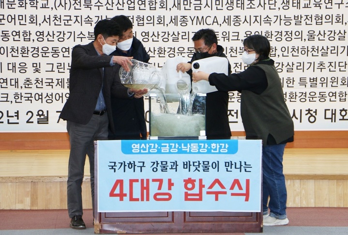 [나주=뉴시스] 이창우 기자= 7일 전남 나주시청 대회의실에서 '4대강 국가하구 생태복원 국정과제 채택 전국회의' 출범식이 열린 가운데 참석자들이 4대강 강물과 바닷물을 하나로 합치는 합수식 퍼포먼스를 하고 있다. (사진=나주시 제공) 2022.02.07 photo@newsis.com *재판매 및 DB 금지