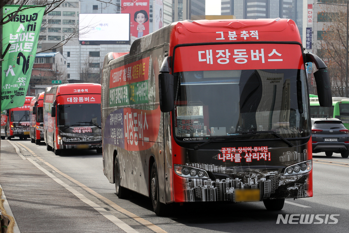 [서울=뉴시스] 조성우 기자 = 대장동버스 연합 참여자들이 7일 오전 서울 중구 서울시청 앞 광장에서 '대장동게이트 주범 구속 처벌 촉구 민심 대장동버스  연합 출정식'을 하고 있다. 2022.02.07. xconfind@newsis.com