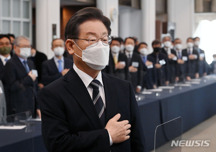 [서울=뉴시스] 국회사진기자단 = 이재명 더불어민주당 대선 후보가 7일 서울 중구 프레스센터에서 열린 민주정부 장·차관급 이재명 후보 지지선언 행사에서 국기에 대한 경례를 하고 있다. 2022.02.07. photo@newsis.com