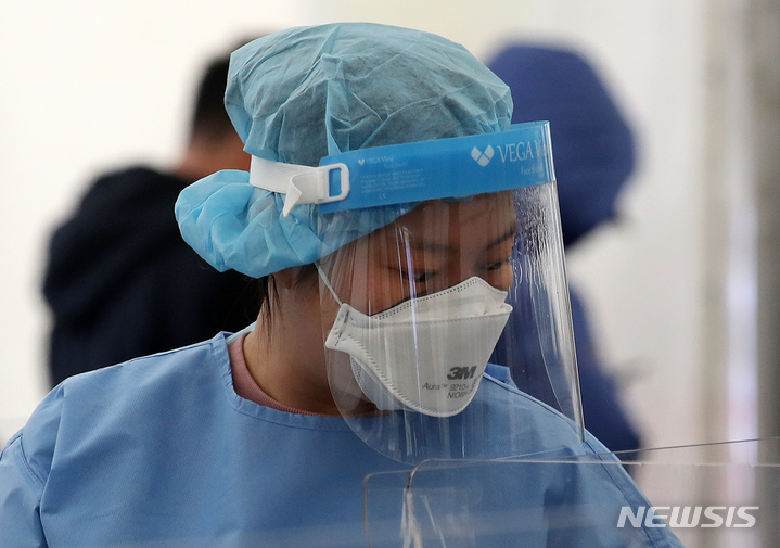 [서울=뉴시스] 조성우 기자 = 코로나19 신규 확진자가 3만 6719명으로 집계된 8일 오전 서울 송파구 보건소에 마련된 코로나19 선별진료소에서 의료진이 신속항원검사를 하는 시민들을 안내하는 가운데 페이스쉴드에 습기가 차 있다. 2022.02.08. xconfind@newsis.com
