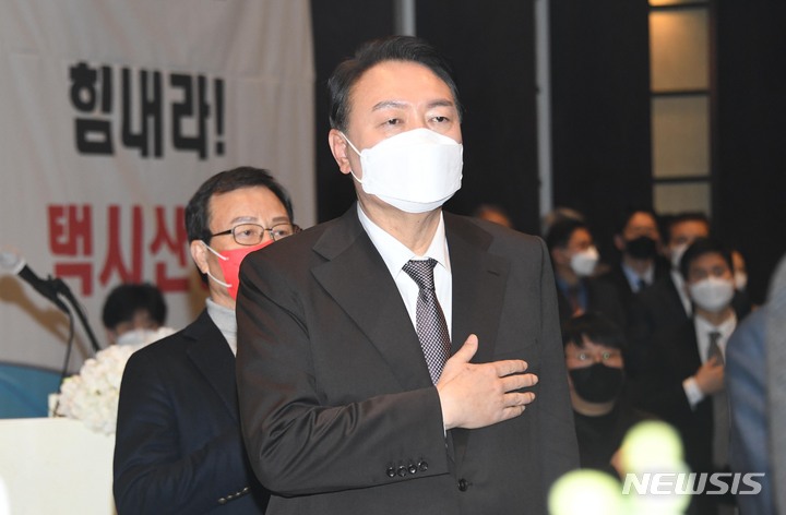 [서울=뉴시스] 국회사진기자단 = 윤석열 국민의힘 대선 후보가 8일 서울 송파구 교통회관에서 열린 '힘내라 택시! 소통의 날' 정책간담회에서 국기에 대한 경례를 하고 있다. 2022.02.08. photo@newsis.com