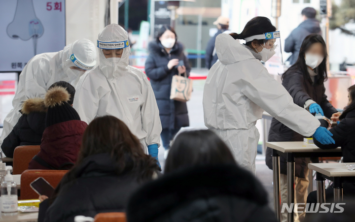[서울=뉴시스] 조성우 기자 = 8일 오후 서울 강남구 보건소 선별진료소에서 구청 관계자들이 신속항원검사를 하는 시민들을 안내하고 있다. 2022.02.08. xconfind@newsis.com