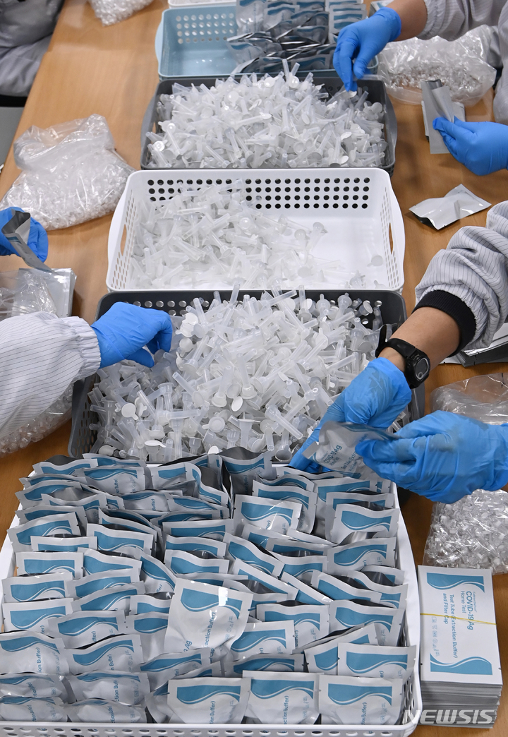 [군포=뉴시스] 김종택기자 = 코로나19 재택치료자가 역대 최고치를 기록한 9일 오후 경기도 군포시 휴마시스 공장에서 직원들이 신속항원검사 키트를 포장하고 있다. 10일부터 코로나19 증상이 없거나 경미한 재택치료 환자는 정부나 의료기관의 관리감독 없이 스스로 건강상태를 체크하고 자가격리 지침도 알아서 지키는 시스템으로 전환된다. 2022.02.09. jtk@newsis.com