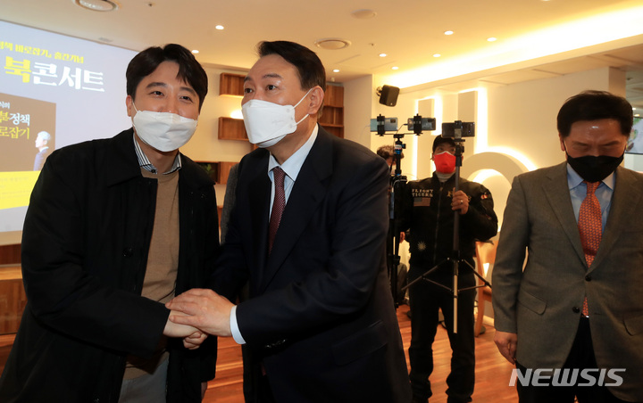[서울=뉴시스] 국회사진기자단 = 윤석열 국민의힘 대선 후보와 이준석 대표가 9일 오후 서울 여의도 한 카페에서 열린 김근식 전 선대위 정세분석실장의 대북정책 바로잡기 출간기념 북콘서트에서 악수하고 있다. 2022.02.09. photo@newsis.com