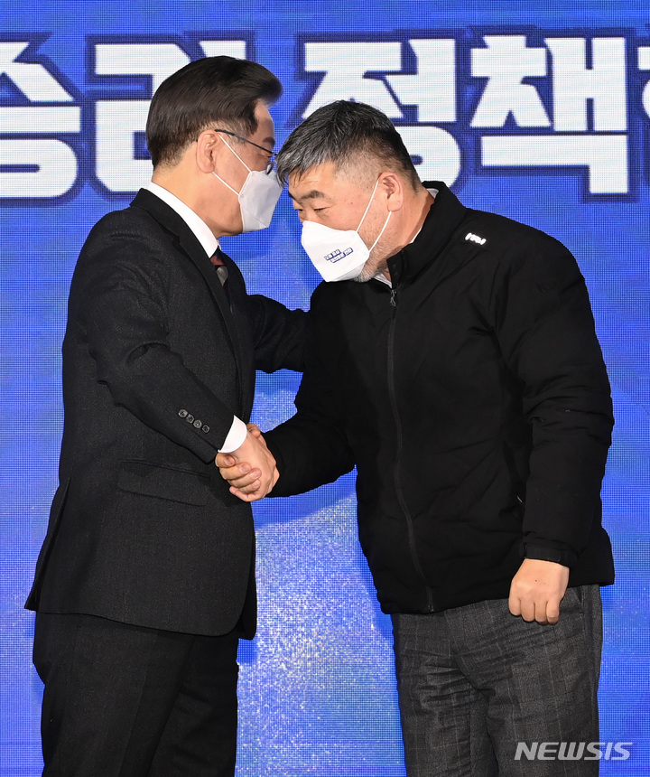 [서울=뉴시스] 국회사진기자단 = 이재명 더불어민주당 대선 후보가 10일 서울 영등포구 한국노총에서 열린 노동 정책 협약식에서 김동명 한국노총 위원장과 악수하고 있다. 2022.02.10. photo@newsis.com