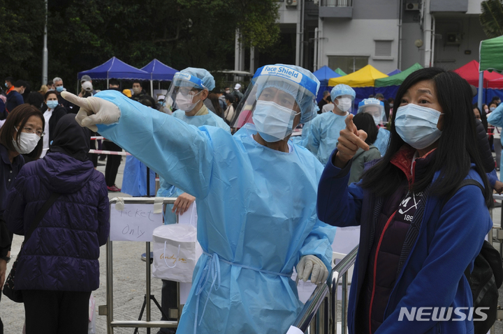 [홍콩=AP/뉴시스]&nbsp; 2022년 2월 10일 홍콩 란타우섬 디스커버리 베이에 마련된 코로나19 임시 검사소에서 검사를 받으려는 한 주민이 안내를 받고 있다. 2025.07.10.