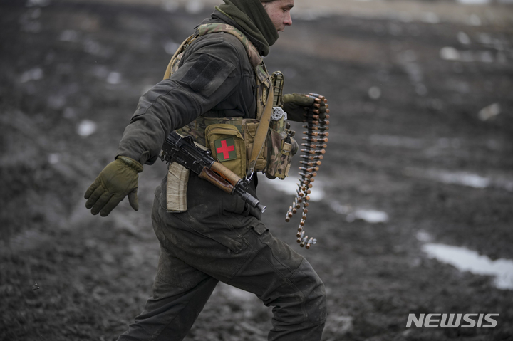 [도네츠크=AP/뉴시스] 10일(현지시간) 우크라이나 동부 도네츠크 지역의 합동작전 통제구역에서 훈련 중인 한 우크라이나군 병사가 전달할 탄약을 들고 달리고 있다. 2022.02.11.