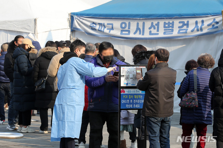 [서울=뉴시스] 백동현 기자 = 지난 11일 오전 서울 송파구 올림픽공원 평화의문 광장 임시선별검사소에서 의료진이 시민에게 안내하고 있다. 2022.02.11. livertrent@newsis.com