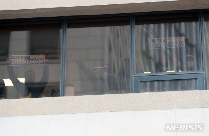 [서울=뉴시스] 고승민 기자 = 민주노총 전국택배노조 CJ대한통운본부 회원들이 지난 11일 서울 CJ대한통운 본사에서 창문을 통해 손을 흔들고 있다. 2022.02.11. kkssmm99@newsis.com