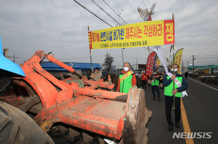 [제주=뉴시스] 우장호 기자 = 제주시 외도동 신산마을·진흥아트빌 자원순환관련시설 반대 비상대책위원회 관계자들이 12일 오전 제주시 내도동 신산마을회관 인근 도로에서 관련 시설 사업허가를 반대하는 거리 시위를 하고 있다. 2022.02.12. woo1223@newsis.com