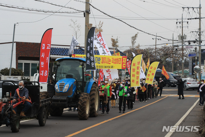 [제주=뉴시스] 우장호 기자 = 제주시 외도동 신산마을·진흥아트빌 자원순환관련시설 반대 비상대책위원회 관계자들이 12일 오전 제주시 내도동 신산마을회관 인근 도로에서 관련 시설 사업허가를 반대하는 거리 시위를 하고 있다. 2022.02.12. woo1223@newsis.com