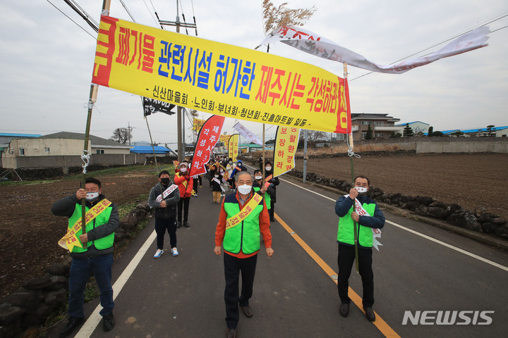 [제주=뉴시스] 우장호 기자 = 제주시 외도동 신산마을·진흥아트빌 자원순환관련시설 반대 비상대책위원회 관계자들이 12일 오전 제주시 내도동 신산마을회관 인근 도로에서 관련 시설 사업허가를 반대하는 거리 시위를 하고 있다. 2022.02.12. woo1223@newsis.com