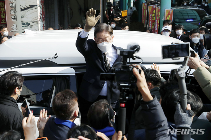 [세종=뉴시스] 최동준 기자 = 이재명 더불어민주당 대선 후보가 12일 세종 조치원읍 세종전통시장을 방문해 연설을 마치고 이동하며 인사하고 있다. 2022.02.12. photocdj@newsis.com