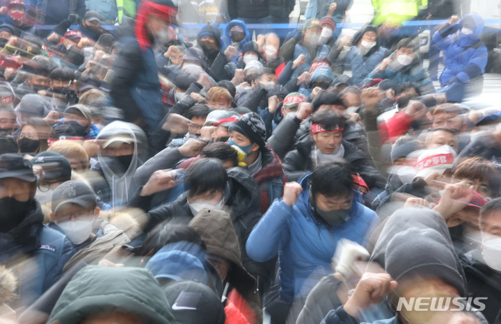 [서울=뉴시스] 권창회 기자 = 전국택배노동조합 소속 조합원들이 12일 오전 서울 중구 CJ대한통운 본사 앞에서 열린 '과로사대책 사회적합의 이행, CJ대한통운 대화 촉구, 조속한 해결을 위한 108배'를 마치고 구호를 외치고 있다. 2022.02.12. kch0523@newsis.com