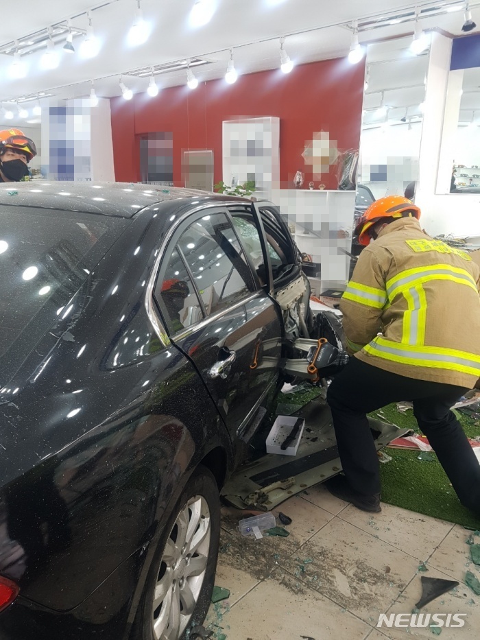 [대구=뉴시스] 이지연 기자 = 13일 오전 11시25분 대구 동구 방촌동의 한 안경점에 40대 A씨가 몰던 승용차가 인도를 넘어 매장으로 돌진했다. (사진=동부소방서 제공) 2022.02.13. photo@newsis.com