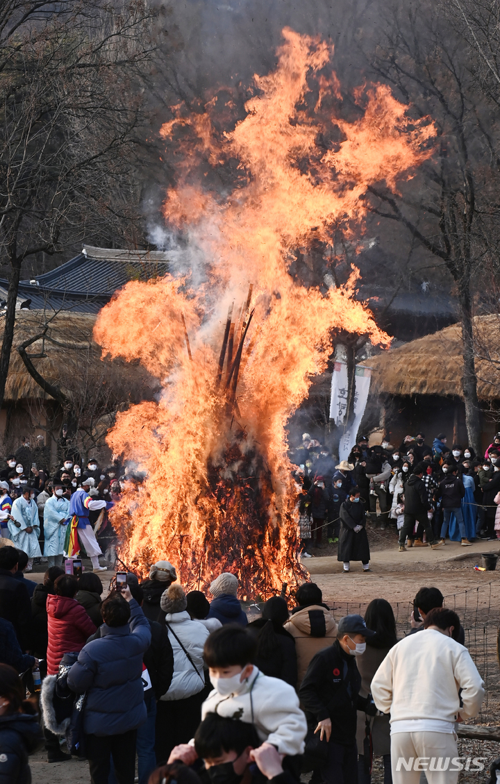 [용인=뉴시스] 김종택기자 = 13일 오후 경기도 용인 한국민속촌에서 열린 정월대보름 달집태우기 행사에서 관람객들이 활활 타오르는 달집을 바라보고 있다. 2022.02.13. jtk@newsis.com