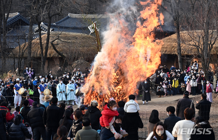 [용인=뉴시스] 김종택기자 = 13일 오후 경기도 용인 한국민속촌에서 열린 정월대보름 달집태우기 행사에서 관람객들이 활활 타오르는 달집을 바라보고 있다. 2022.02.13. jtk@newsis.com