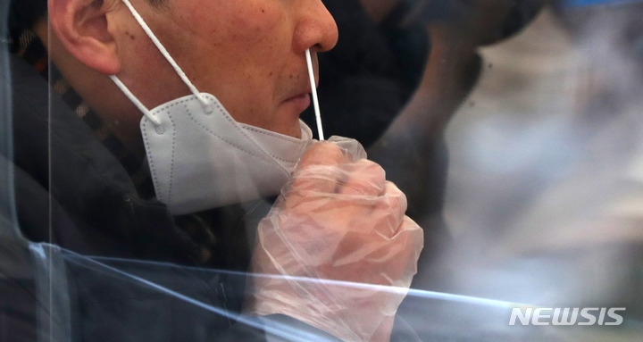 [서울=뉴시스] 추상철 기자 = 코로나19 신규 확진자수가 닷새째 5만명대를 기록한 14일 오전 서울 송파구 선별진료소에서 시민이 코로나19 신속항원검사를 하고 있다. 2022.02.14. scchoo@newsis.com