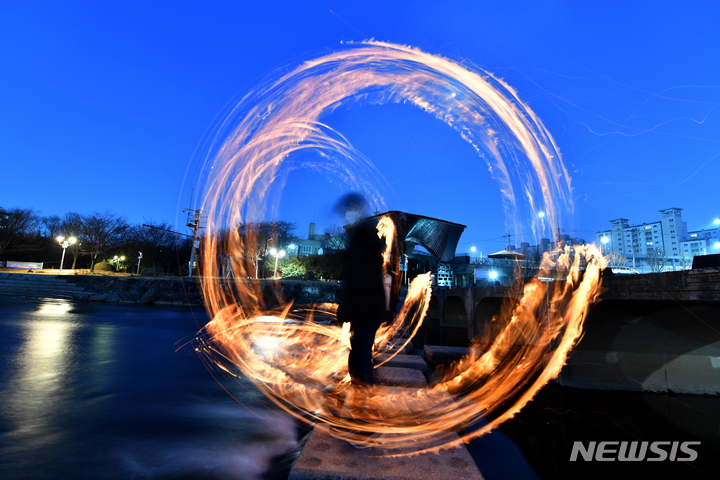 [광주=뉴시스] 류형근 기자 = 정월대보름을 하루 앞둔 14일 오후 광주 북구 임동 광주천 두물머리에서 북구청·행정복지센터 직원들이 '코로나19 종식과 광주 안녕'을 기원하며 쥐불놀이하고 있다. 2022.02.14. hgryu77@newsis.com