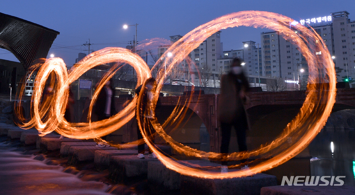 [광주=뉴시스] 류형근 기자 = 정월대보름을 하루 앞둔 14일 오후 광주 북구 임동 광주천 두물머리에서 북구청·행정복지센터 직원들이 '코로나19 종식과 광주 안녕'을 기원하며 쥐불놀이하고 있다. 2022.02.14. hgryu77@newsis.com