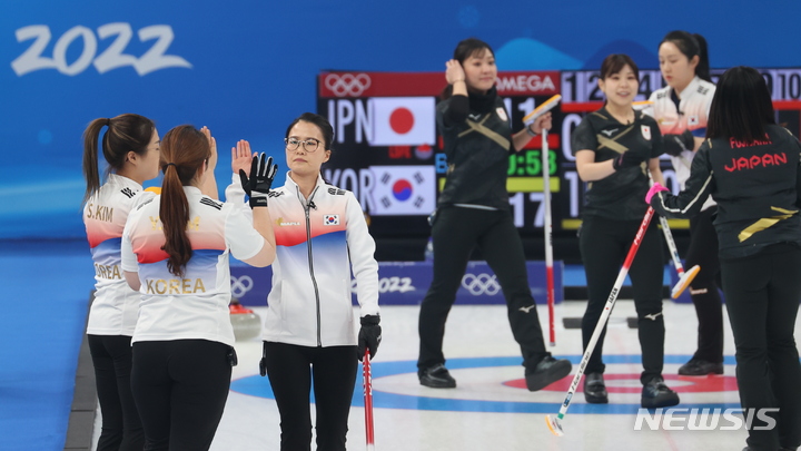 [베이징(중국)=뉴시스] 홍효식 기자 = 14일 중국 베이징 내셔널 아쿠아틱 센터에서 열린 2022 베이징 동계올림픽 컬링 여자 한국과 일본과의 경기, 대한민국 팀킴 스킵 김은정이 김영미, 김선영과 하이파이브 하고 있다. 팀킴은 9엔드 때 10:5로 승리하며 경기를 마무리했다. 2022.02.14. yesphoto@newsis.com