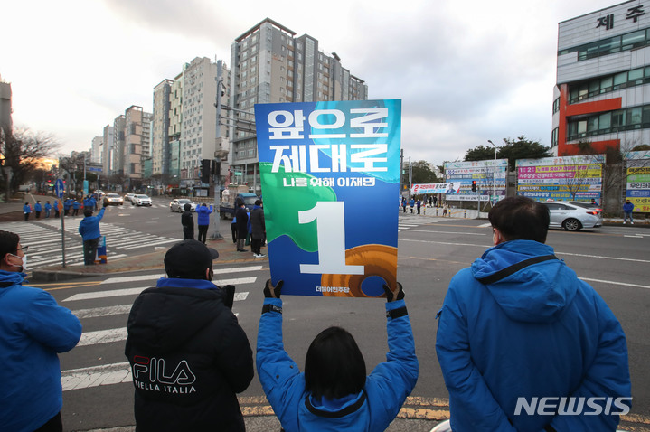 [제주=뉴시스] 우장호 기자 = 제20대 대통령 선거 공식 선거운동 첫날인 15일 오전 제주시 노형동 롯데마트 사거리에서 더불어민주당 이재명 제라진 제주선거대책위원회 관계자들이 유권자들을 향해 지지를 호소하고 있다. '제라진'은 최고를 뜻하는 제주도 방언이다. 2022.02.15. woo1223@newsis.com