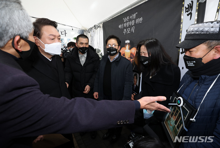 [서울=뉴시스] 국회사진기자단 = 제20대 대통령 선거 공식 선거운동이 시작된 15일 오전 윤석열 국민의힘 대선 후보가 서울 청계광장에 마련된 코로나 백신접종 사망자 분향소에서 유족들을 만나고 있다. 2022.02.15. photo@newsis.com