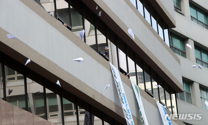 [서울=뉴시스] 이영환 기자 = 김재연 진보당 대선후보가 15일 오전 서울 중구 CJ대한통운 앞에서 열린 20대 대선 선거운동 출정식에 참석해 점거농성중인 택배노조원들을 향해 인사 하자 노조원들이 종이비행기를 날리고 있다. 2022.02.15. 20hwan@newsis.com