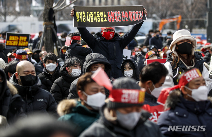 [서울=뉴시스] 정병혁 기자 = 코로나피해자영업총연합 회원들이 15일 오후 서울 종로구 광화문시민열린마당에서 열린 코로나 피해 실질 보상 촉구 정부 규탄대회에서 피켓을 들고 구호를 외치고 있다. 2022.02.15. jhope@newsis.com