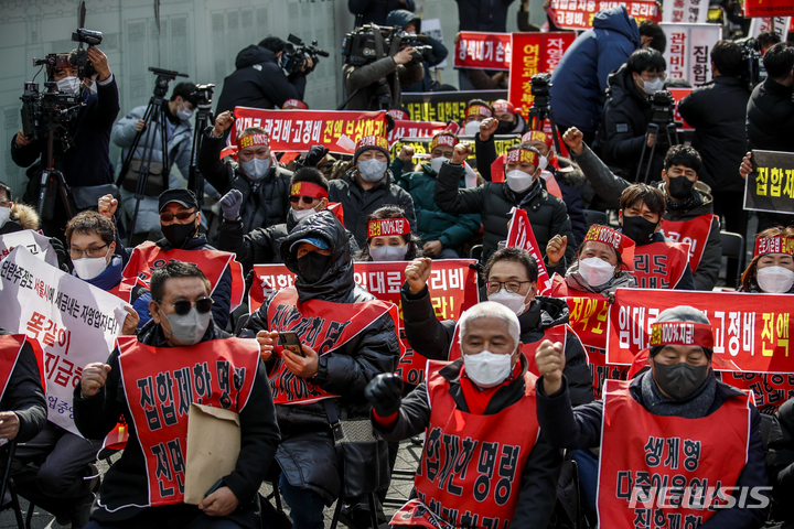 [서울=뉴시스] 정병혁 기자 = 코로나피해자영업총연합 회원들이 15일 오후 서울 종로구 광화문시민열린마당에서 열린 코로나 피해 실질 보상 촉구 정부 규탄대회에서 피켓을 들고 구호를 외치고 있다. 2022.02.15. jhope@newsis.com