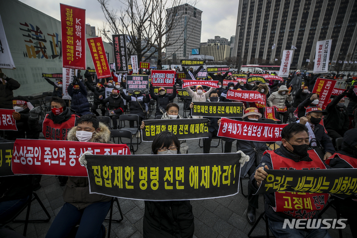 [서울=뉴시스] 정병혁 기자 = 코로나피해자영업총연합 회원들이 15일 오후 서울 종로구 광화문시민열린마당에서 열린 코로나 피해 실질 보상 촉구 정부 규탄대회에서 피켓을 들고 구호를 외치고 있다. 2022.02.15. jhope@newsis.com