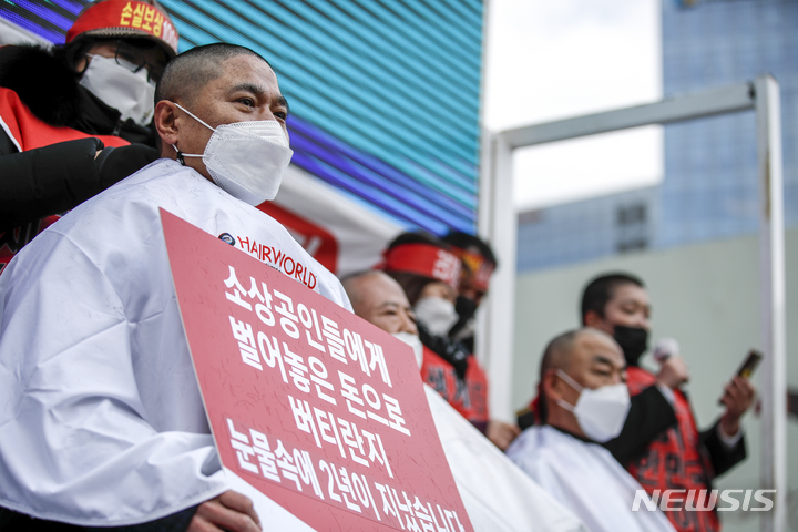 [서울=뉴시스] 정병혁 기자 = 코로나피해자영업총연합 회원들이 15일 오후 서울 종로구 광화문시민열린마당에서 열린 코로나 피해 실질 보상 촉구 정부 규탄대회에서 삭발을 하고 있다. 2022.02.15. jhope@newsis.com