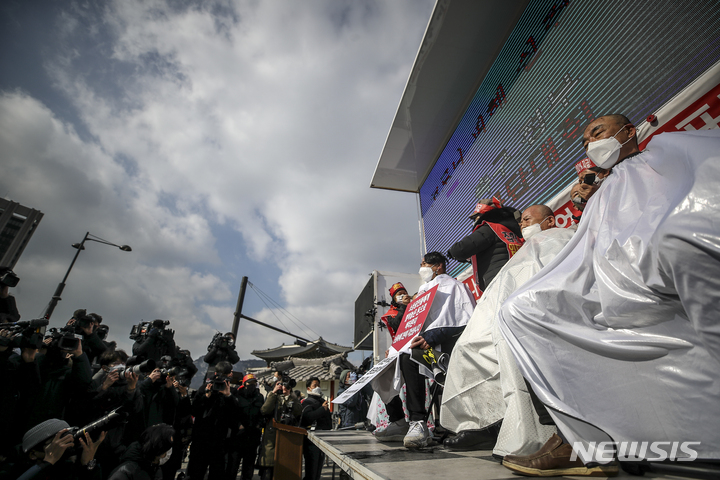 [서울=뉴시스] 정병혁 기자 = 코로나피해자영업총연합 회원들이 지난 15일 오후 서울 종로구 광화문시민열린마당에서 열린 코로나 피해 실질 보상 촉구 정부 규탄대회에서 삭발을 하고 있다. 2022.02.15. jhope@newsis.com
