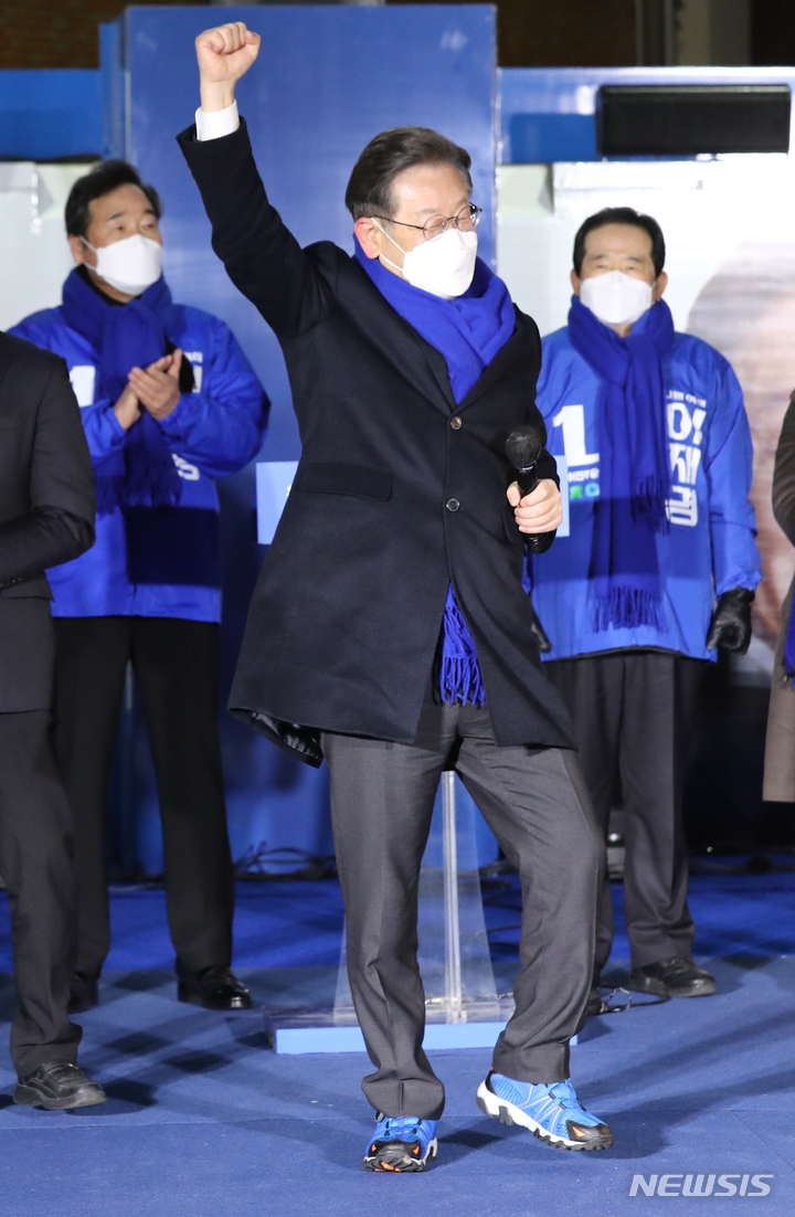 [서울=뉴시스] 국회사진기자단 = 이재명 더불어민주당 대선 후보가 제20대 대통령선거 공식 선거운동이 시작된 15일 서울 강남고속버스터미널에서 열린 서울 첫 집중 유세에 참석해 부산 청년지지자에게 받은 운동화를 소개하며 달리기 포즈를 취하고 있다. 2022.02.15. photo@newsis.com