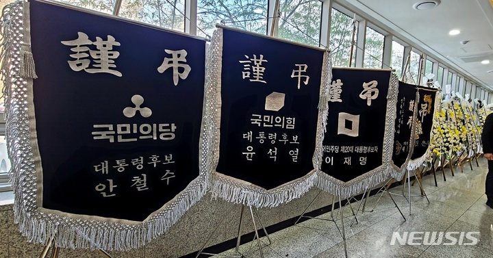[천안=뉴시스] 이종익 기자 = 국민의당 안철수 대선 후보 유세버스 안에서 숨진 채 발견된 논산·계룡·금산지역 선거대책위원장의 빈소가 마련된 충남 천안의 단국대병원 장례식장에 16일 오후 안철수 국민의당 대선후보와 윤석열 국민의힘 대선후보, 이재명 더불어민주당 대선후보 등의 조기(弔旗)가 놓여져 있다. 2022.02.16. 007news@newsis.com